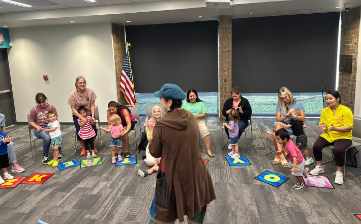 Librarian leading storytime for circle of children and parents