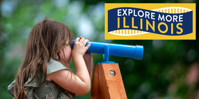 Photo of young girl looking through blue play telescope with "Explore More Illinois" logo overlay