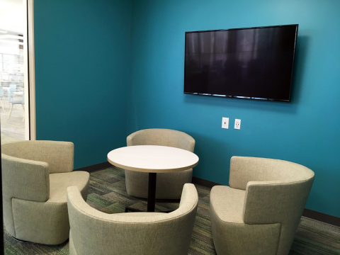 Study Room A interior shot with blue walls, mounted television, circular table and four chairs