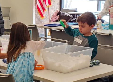 Children examining bins of snow