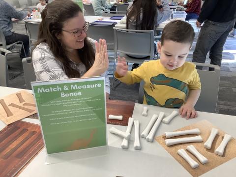 Adult and child with faux dinosaur bones activity.