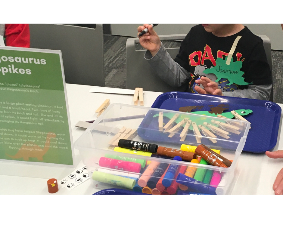 Dinosaur shape with letters spelling child's name on clothes pins as spikes.